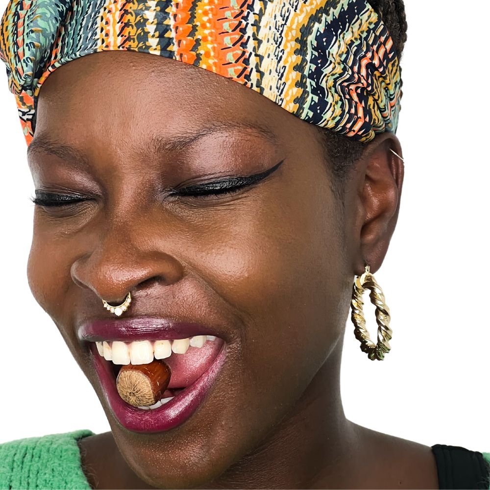 femme peau grasse avec une noisette dans la bouche dont est issue l'huile de noisette
