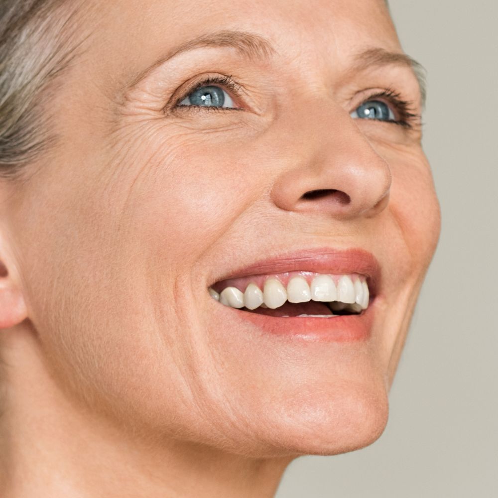 photo d'une femme souriante avec une peau mature repulpée