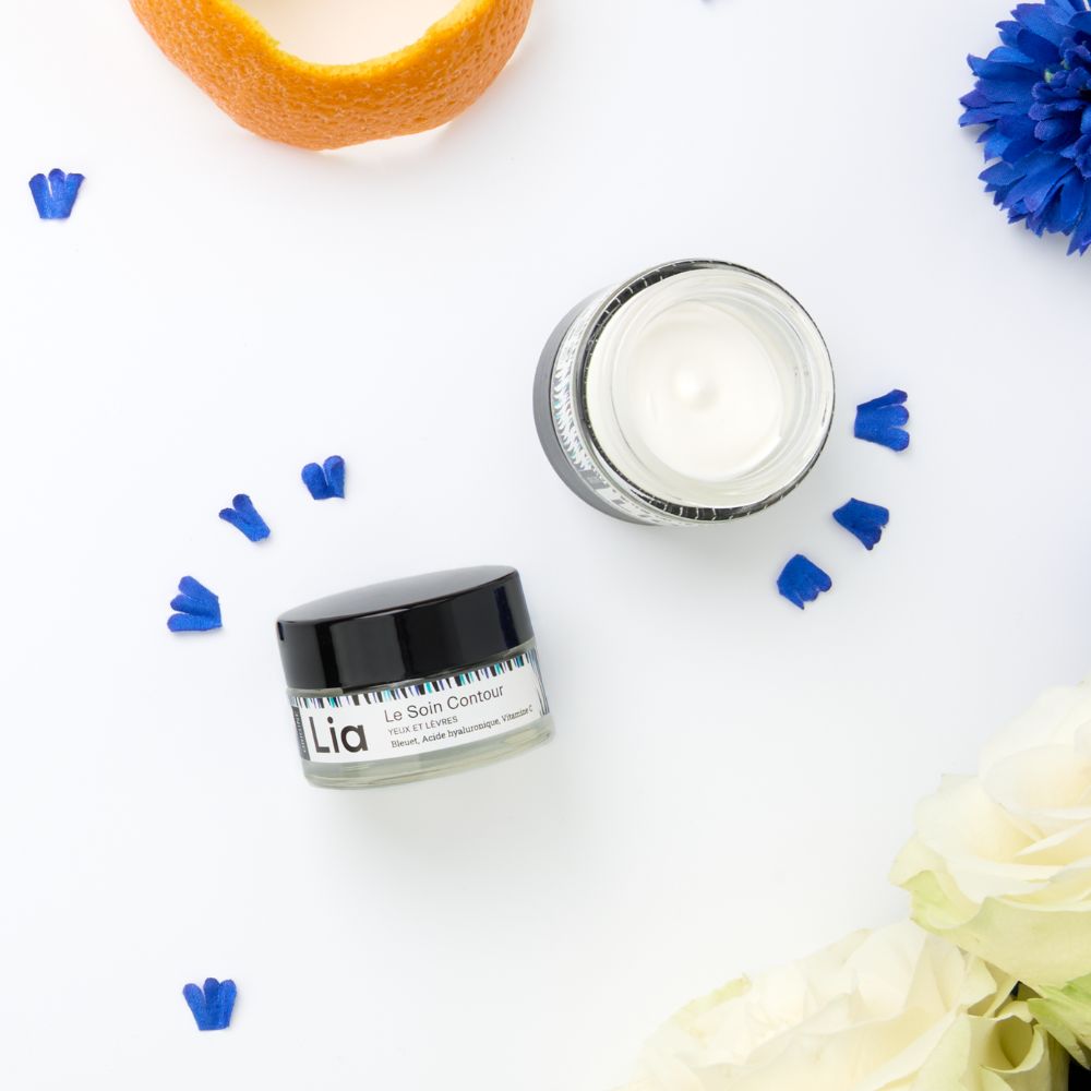 Photo du pot ouvert soin crème contour yeux et lèvres avec fleurs de bleuet